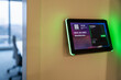 © Westend61 - Wall-mounted tablet displaying meeting room information in an office