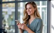 © Rony - Cheerful young woman using smartphone indoors, smiling and enjoying the moment