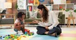 © peopleimages.com - Therapist, woman and girl with clipboard, blocks and talk for evaluation, assessment or exam on floor. Person, psychologist and child with toys, advice and checklist for notes with point at clinic