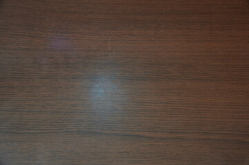 Wall Mural - A wooden surface with a light shining on it. The light is reflected on the wood. The wood is brown in color