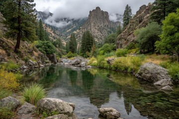 Aufkleber - Scenic river winding through lush green valley beneath cloudy mountains during early morning