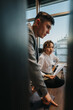 © qunica.com - Two business professionals are engaged in a focused discussion, analyzing documents in a contemporary office environment. The image captures a moment of teamwork, collaboration, and critical thinking.