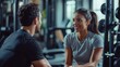 © hidayati - A woman talks to a man inside of a fitness center