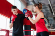 © New Africa - Man in protective gloves having boxing practice with his coach at training center