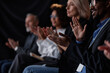 © Seventyfour - Cropped shot of smiling Black man applauding motivational speech while attending professional business conference in auditorium, selective focus on hands