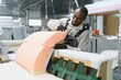 © Serhii - African american Furniture maker assembling sofa in upholstery workshop