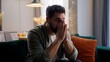 © Yuliia - Anxious tired sad Caucasian business man male guy businessman depressed troubled homeowner bearded client sitting sofa folded hands arms holding head trouble health problem difficulty bankrupt at home