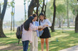 © Crystal - Three young women studying together in a park, reviewing notes and preparing for exams while enjoying the beautiful outdoor scenery