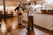 © Drobot Dean - A female owner and a male employee stand opposite each other and take off their aprons, in a cafe