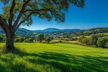 Aufkleber - Expansive green fields and serene village nestled in rolling hills under clear blue sky