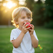 © rana - Happy Child Eating Red Apple Outdoors