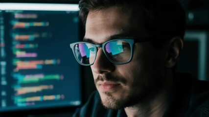Young programmer wearing glasses intently works on code reflected in his lenses in a dark room, symbolizing software development and complex problem-solving in the tech industry