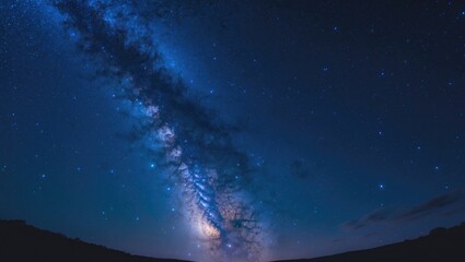 dark background showcasing a panoramic view of the blue night sky with the milky way and stars