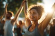 © whitestorm - A radiant woman practicing yoga with a group outdoors, bathed in golden sunlight, feeling energized and connected in a natural setting with a sunny backdrop.