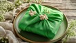 © Lasvu - Wrapping Easter gift - green fabric, card, napkin on plate, close-up.