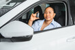 © Serhii - Happy customer showing car key sitting in new vehicle
