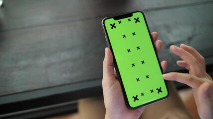 female hands hold mobile phone Green screen smartphone. Chroma Key on a smartphone green screen mockup background