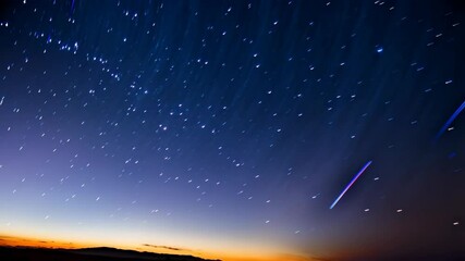 Wall Mural - night sky with star trails created by long exposure time lapse under dark blue sky