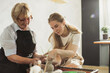 © dsheremeta - Senior woman learning pottery with young instructor in workshop