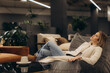 © Roman - Woman Relaxing on a Comfortable Sofa in Modern Home Interior