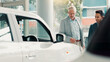 © Claytonon/peopleimages.com - Car dealership, choice or salesman with customer talking for vehicle history, details or features. Transport, people or person with client in showroom for negotiation, report or decision for purchase