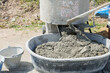 © sorapop - Concrete preparation in progress: cement mixer combines gray mortar and sand into a smooth mix.
