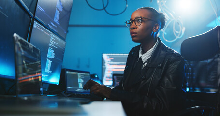 Black woman, reading and coding on computer at night for programming, cyber attack and online information. Person, pc and server script for website phishing, data protection and binary for fraud risk