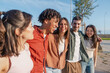 © Martí Rosselló - Diverse group of young friends walking arm in arm outdoors - Happy multicultural young people laughing and walking closely together. Concept of unity, youth and authentic friendship.