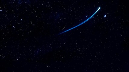 Wall Mural - Bright blue meteor streaks across a dark starry night sky, leaving a shining trail as it falls through the atmosphere.