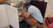 © peopleimages.com - Man, plumber and writing with clipboard by kitchen sink for maintenance report by pipe in home. People, handyman and notes with checklist for drainage system, inspection and repair for leak at house