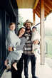 © Doralin - Happy family posing together on porch of modern house