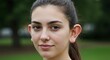© Annetka - Young woman with big ears smiling in a green park during daylight