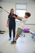© Svitlana - Trainer supervises patient as they perform resistance training with bands