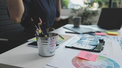 UX/UI designer working on wireframes for a website and mobile app prototype, surrounded by sketches of user-flow and design tools, in concept of website and mobile application design concept.