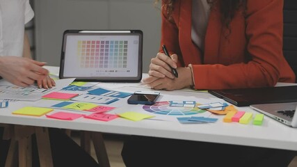 UX/UI designer working on wireframes for a website and mobile app prototype, surrounded by sketches of user-flow and design tools, in concept of website and mobile application design concept.