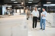 © Serhii - Shop assistant showing ceramic tile to woman in hardware store