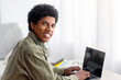© Prostock-studio - Young happy teenage guy using laptop for remote studies at home, mockup for design on screen. Positive youth attending webinar or online class, participating in conference during coronavirus isolation
