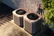 © Grispb - Top view of two outdoor air conditioning units connected to a brick wall, used for residential temperature control. HVAC. Installation. Home maintenance.