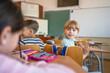 © Miljan Živković - pretty school girl pupil sit in school class and talk with classmate