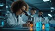© oksa_studio - Team of medical research scientists working with microscope and test tubes, developing cure in pharmaceutical laboratory
