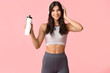 © Pixel-Shot - Sporty young woman with headphones and bottle of water on pink background