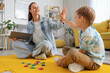© Pixel-Shot - Female speech therapist with little boy giving each other high-five in office