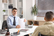 © Pixel-Shot - Young lawyer with papers and client in wheelchair working at office