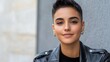 © Kliapko_Photo - Close-up of a Middle Eastern non-binary person with short hair, wearing a stylish leather jacket, exuding confidence.