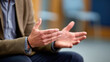 © INT888 - Closeup of person gesturing with hands during conversation or discussion indoor setting, showing expressive hand movements and body language, conveying emphasis or explanation, with blurred