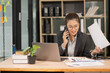© panomporn - Businesswoman calling customer consultant employee in office in the morning, finance manager talking on phone and solving problem with smartphone in corporate communication.