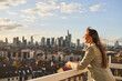© Westend61 - Businesswoman looking at cityscape view while standing on rooftop