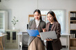 © Wasana - Two women in business attire are looking at a laptop together
