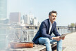 Male entrepreneur with digital tablet sitting on bench during sunny day
