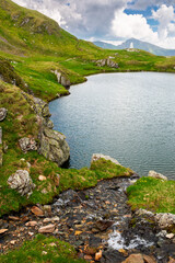 Wall Mural - alpine lake in fagaras mountains. dramatic weather in transylvania highland. rippled water surface